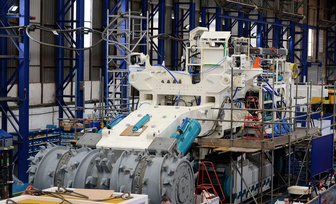 Maquinaria industrial pesada siendo ensamblada en una planta en Asia